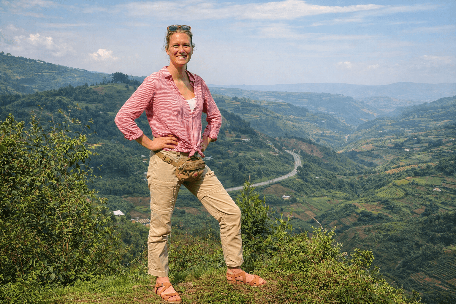Image of a happy tourist lady taken at the top of a trail up a mountain in Uganda